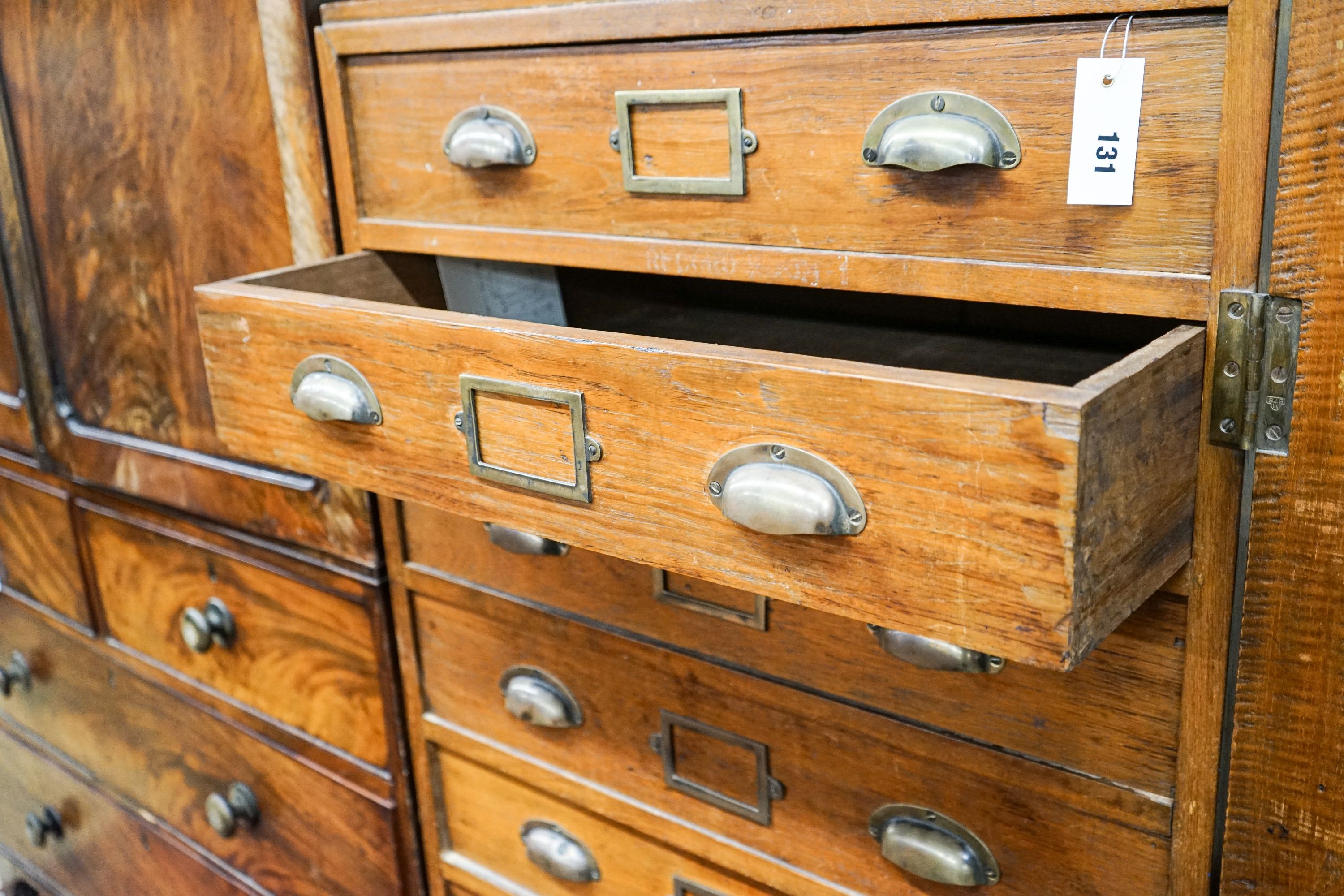 An early 20th century teak nine drawer filing chest with single locking bar, width 70cm, depth 63cm, height 142cm